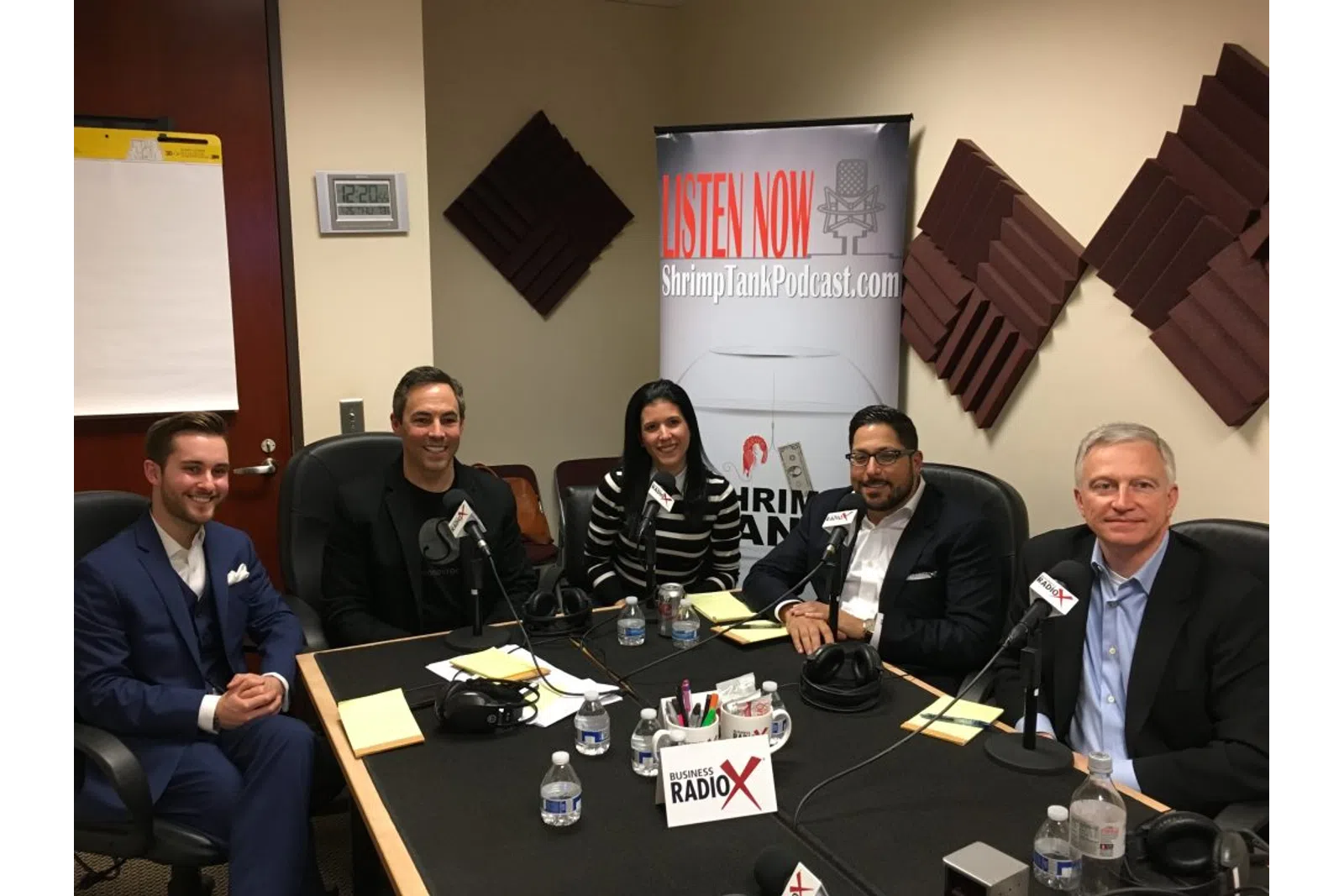 a group of people sitting around a table with microphones