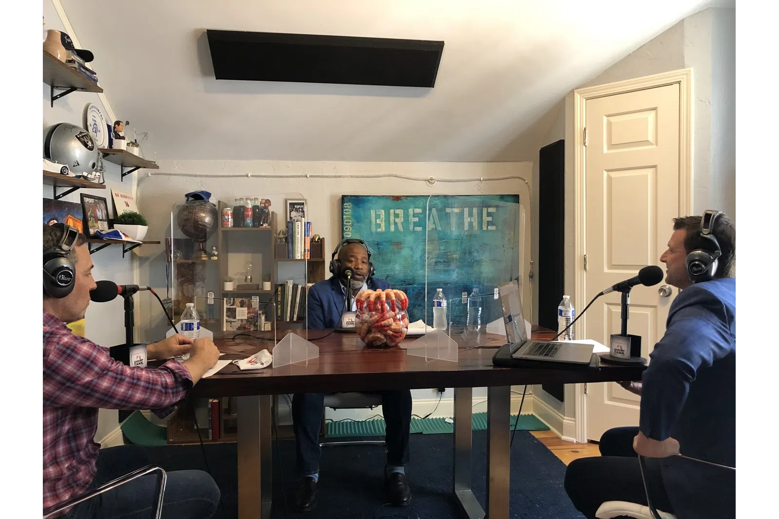 a group of people sitting at a table with microphones and food