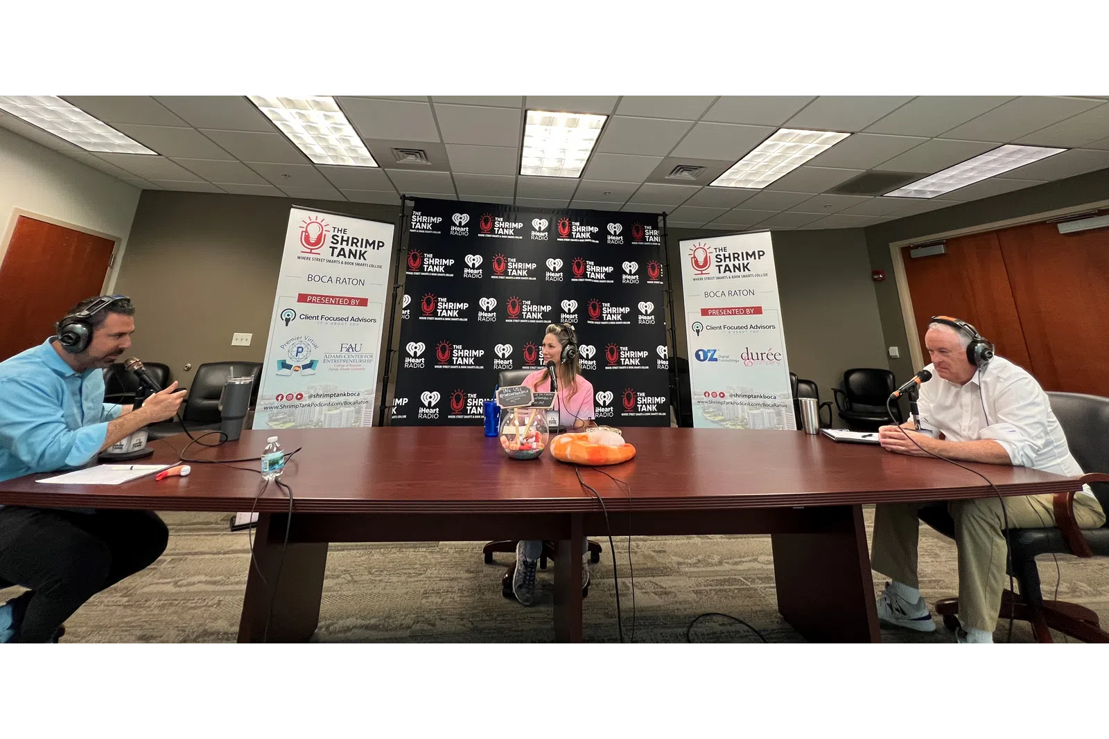 a group of people sitting at a table with microphones
