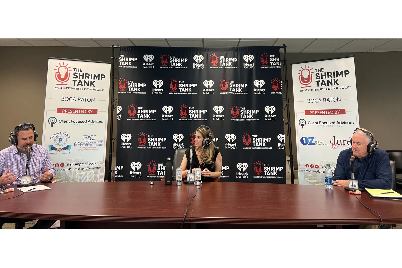 a group of people sitting at a table with microphones