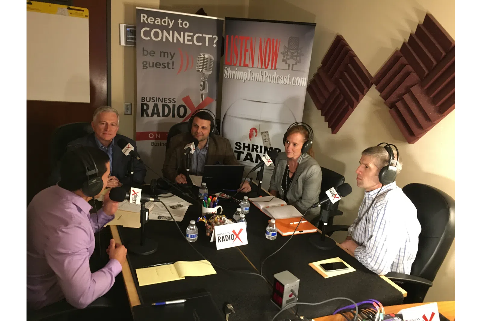 a group of people sitting at a table with microphones