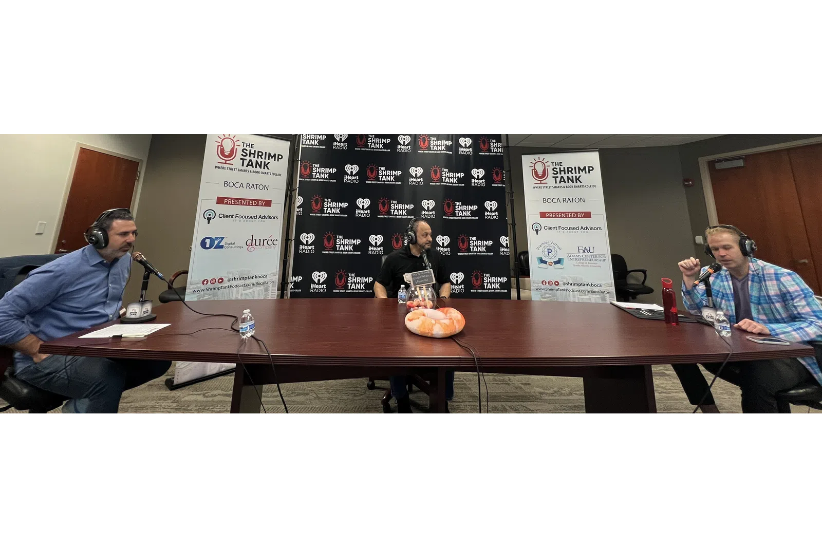 a group of men sitting at a table with microphones