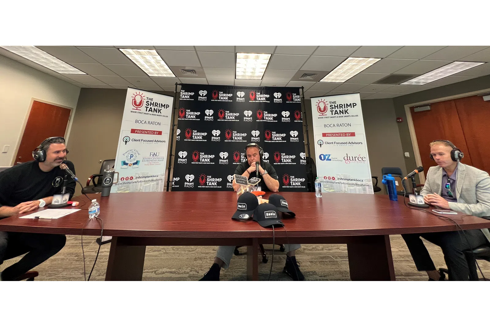 a group of people sitting at a table with microphones