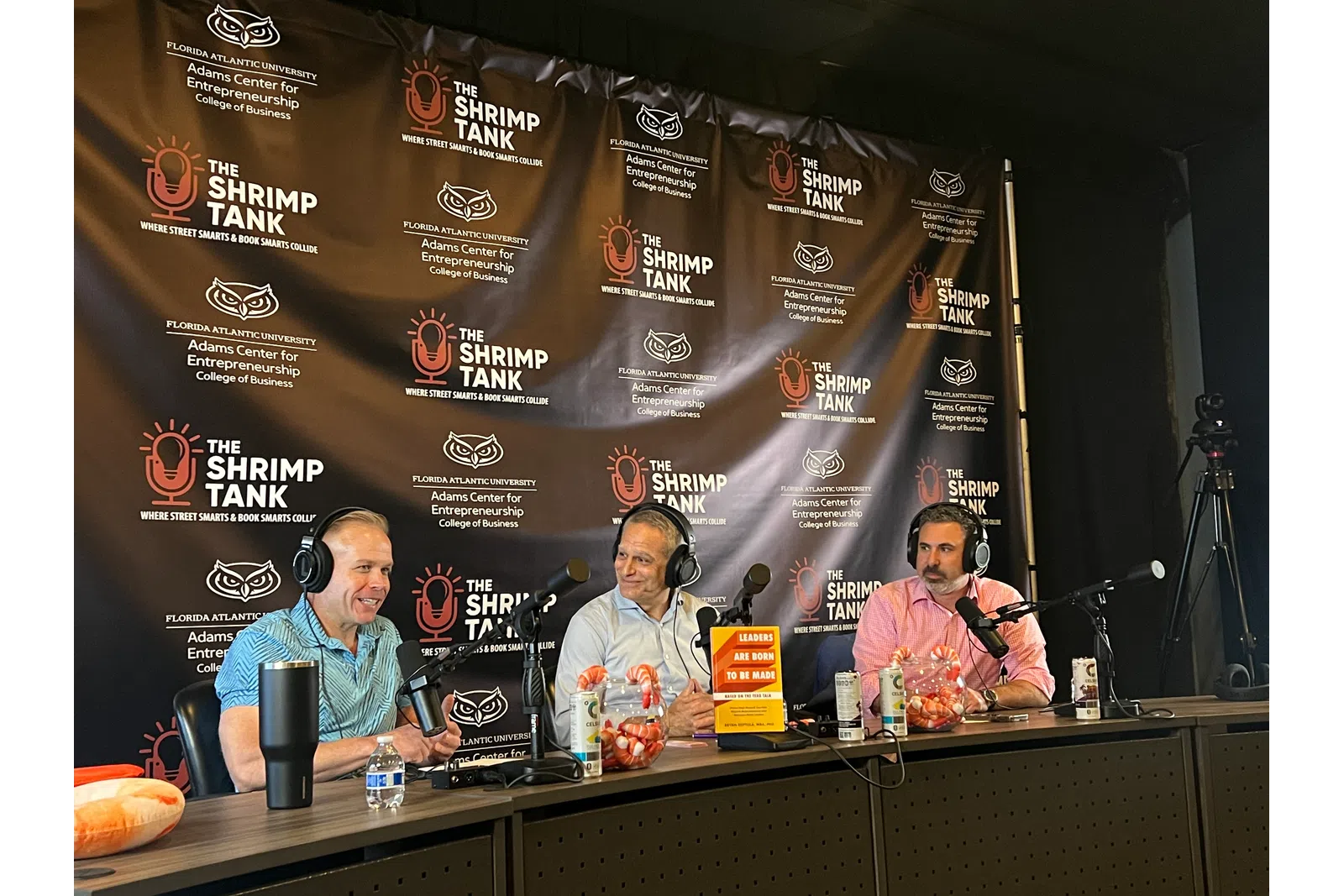 a group of people sitting at a table with microphones