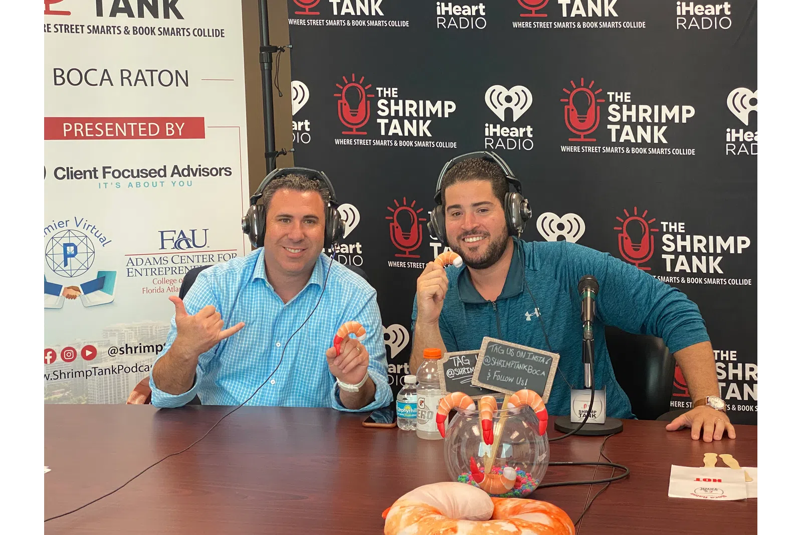 a couple of men wearing headphones and sitting at a table