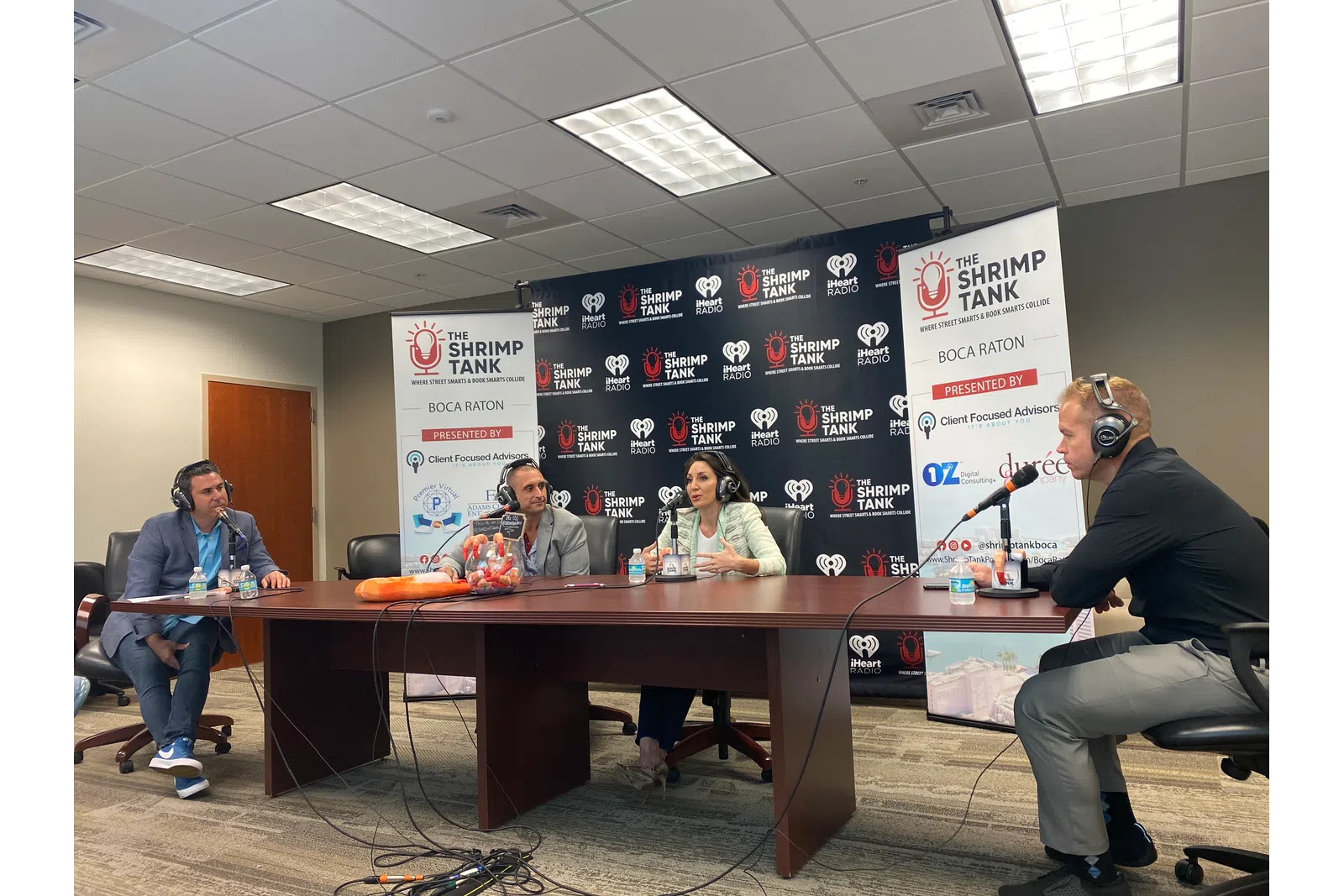 a group of people sitting at a table with microphones