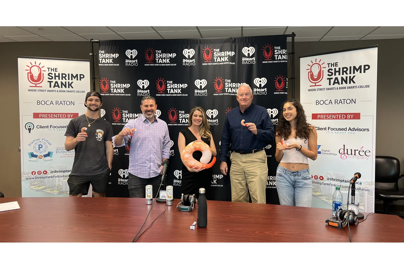 a group of people standing in front of a table with a basketball