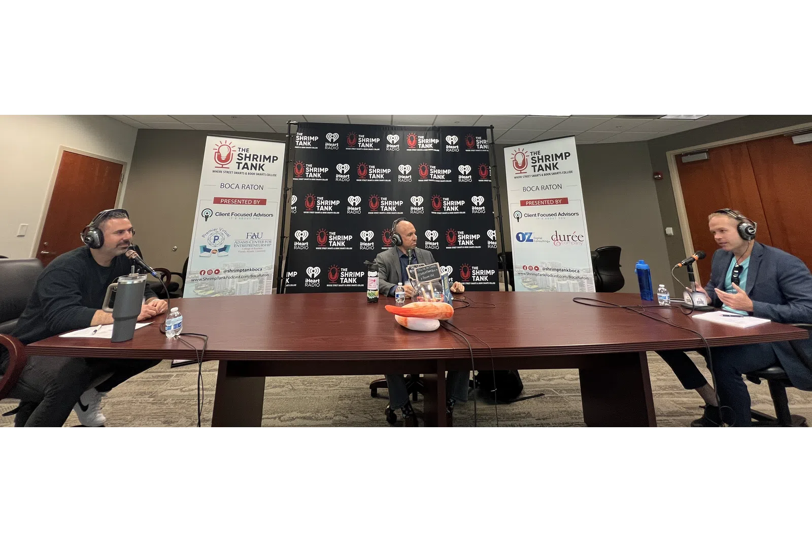a group of people sitting at a table with microphones