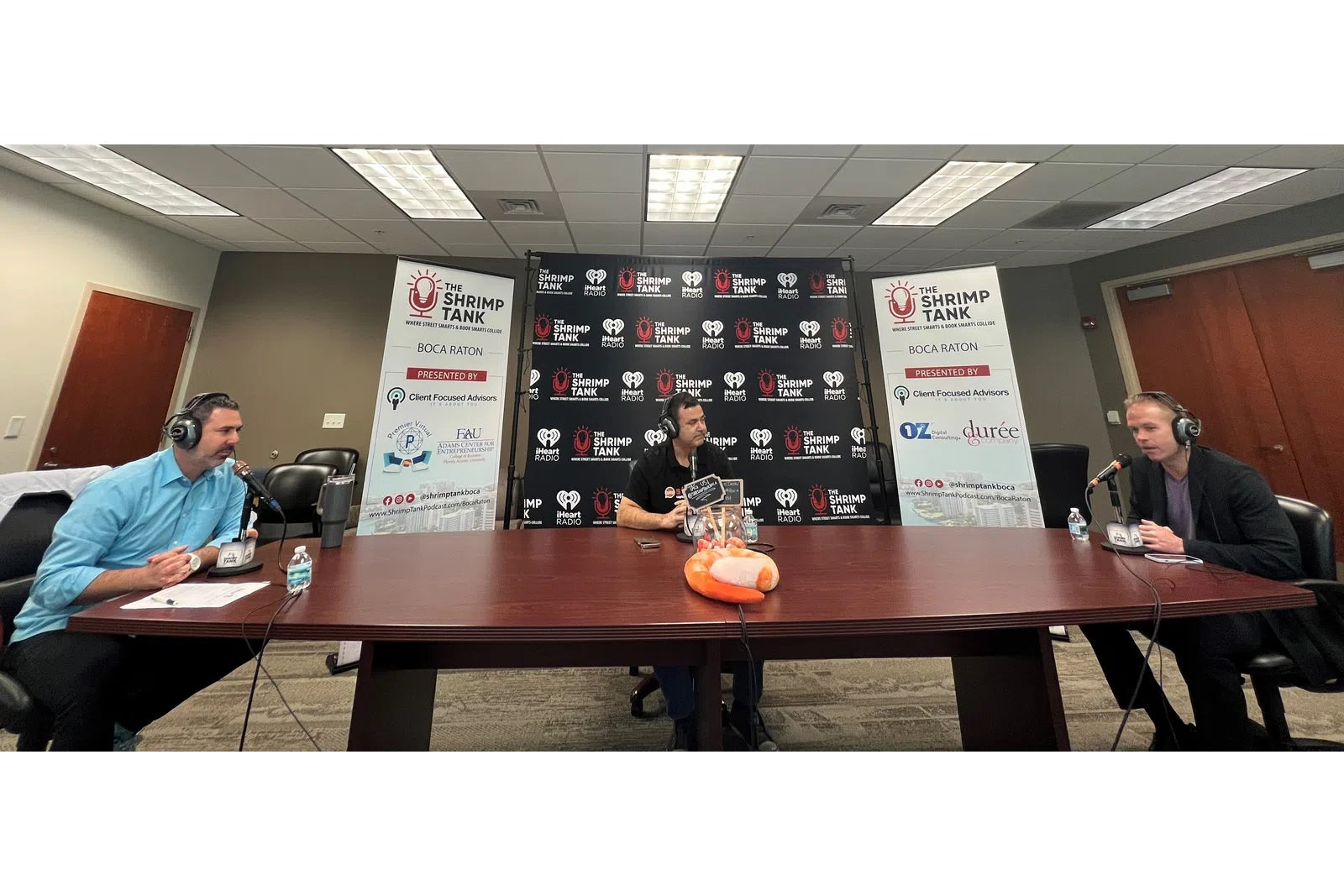 a group of people sitting at a table with microphones