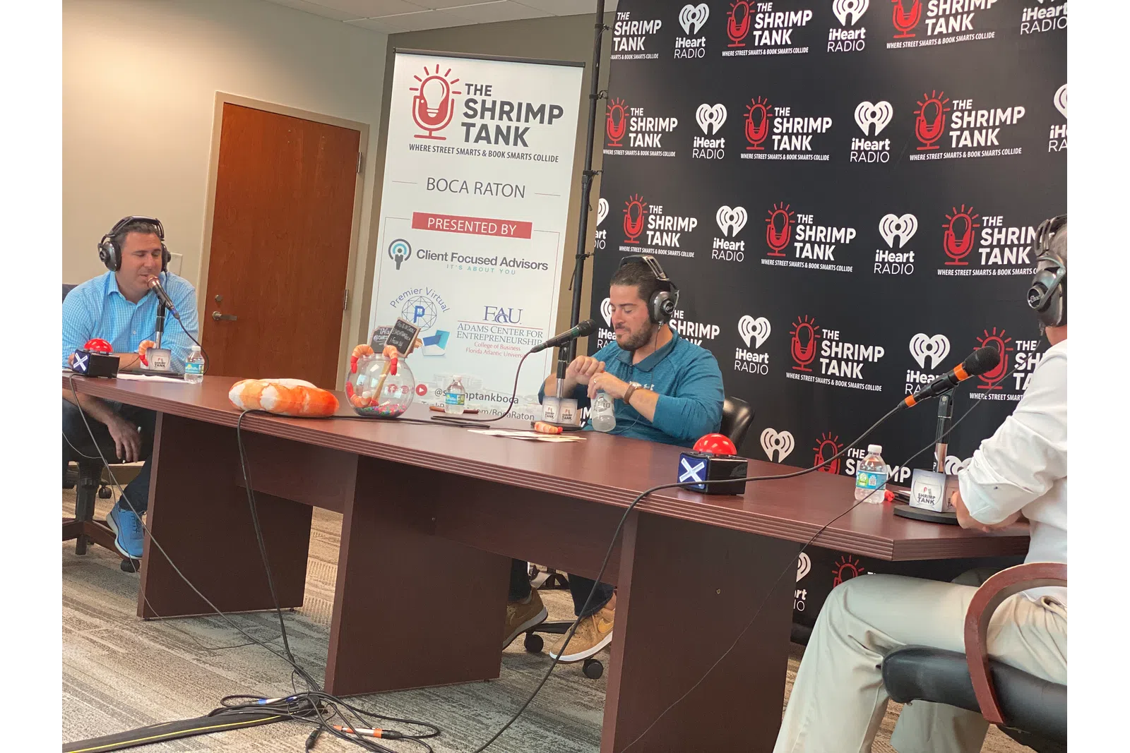 a group of people sitting at a table with microphones