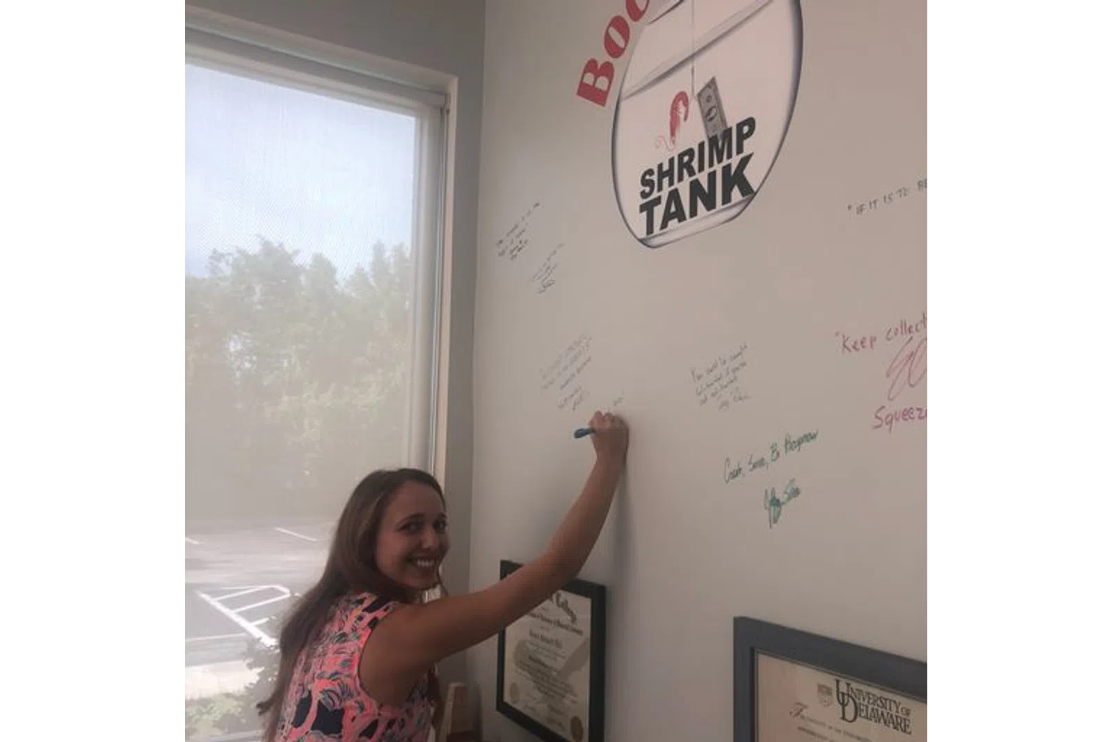 a woman writing on a white board