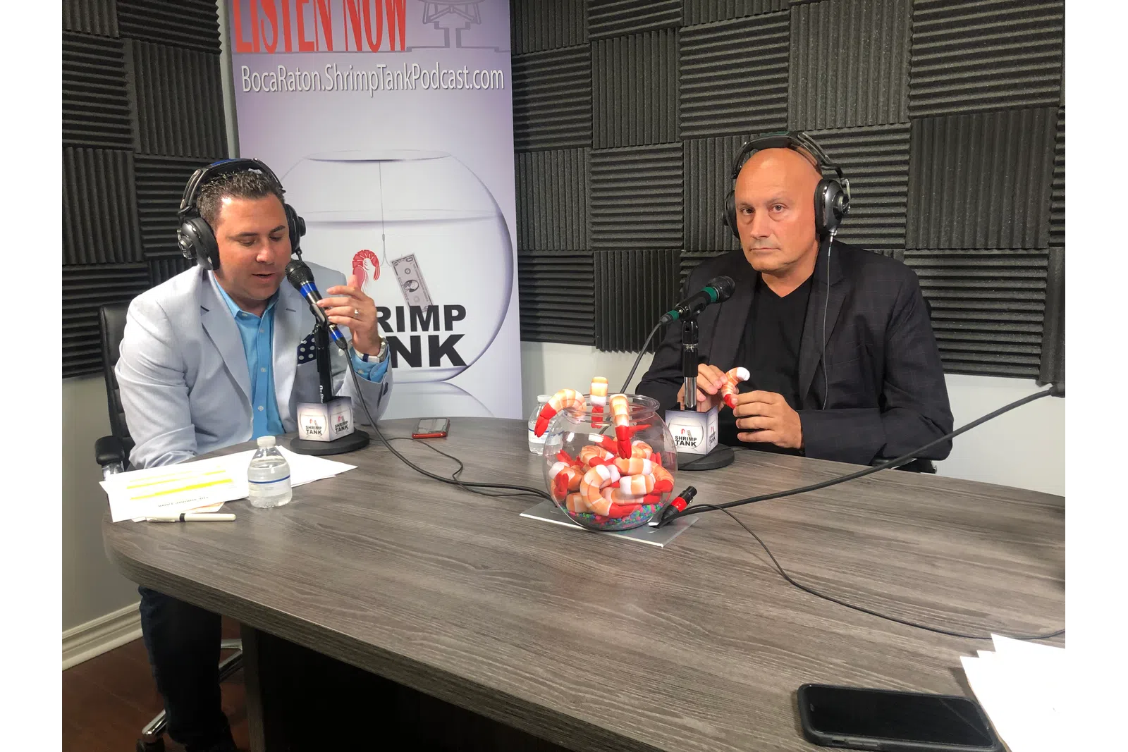 Scott Eddy et al. sitting at a table with microphones and a basket of fruit