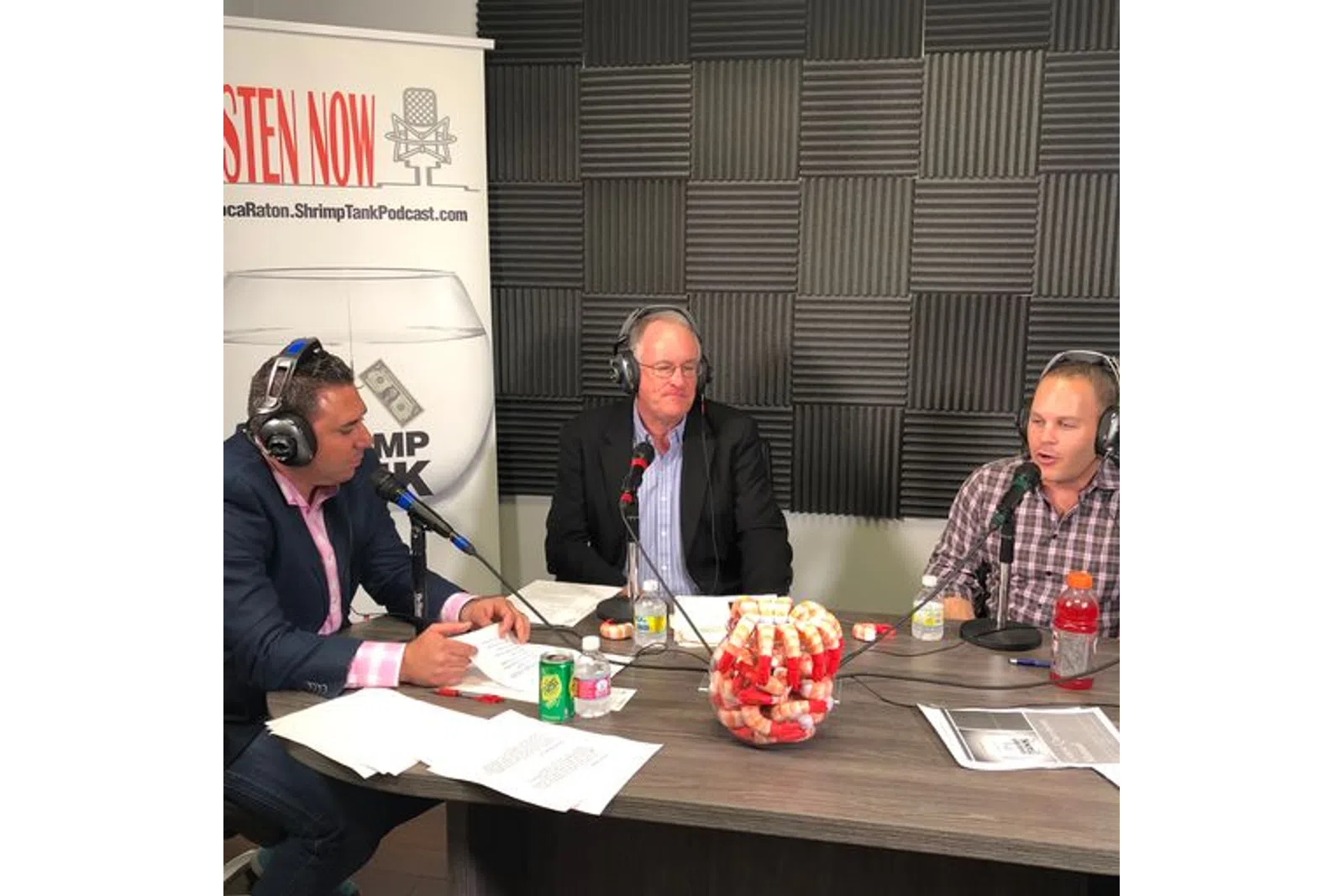 a group of people sitting at a table with microphones
