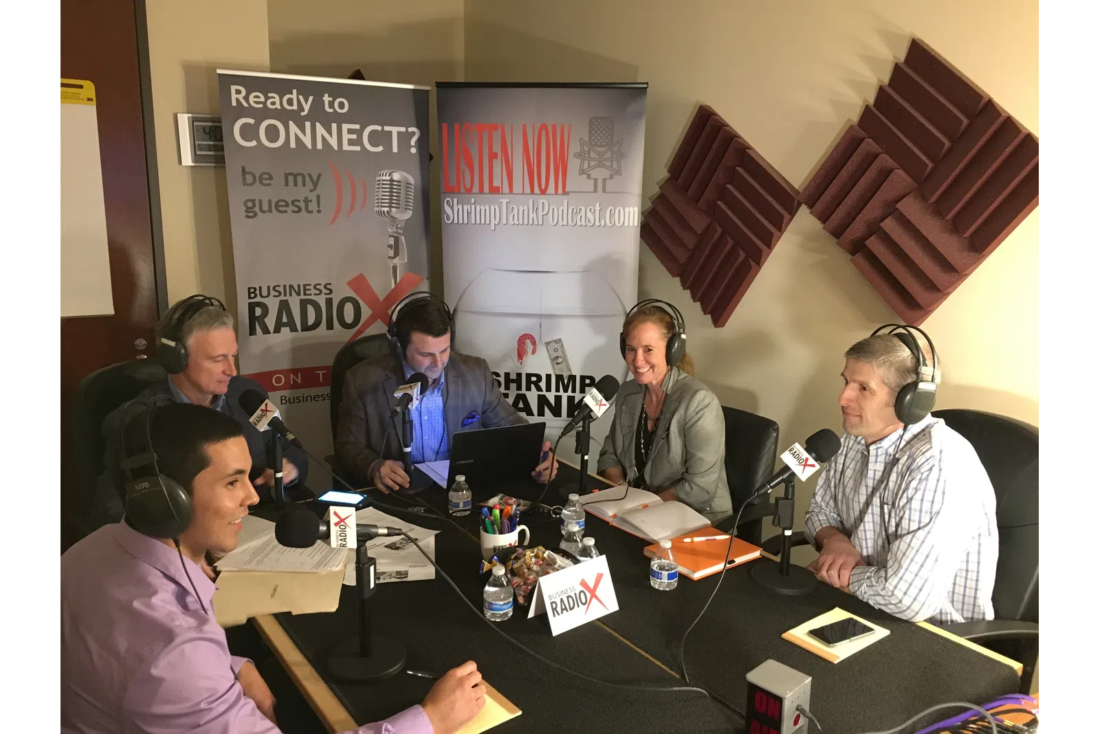 a group of people sitting at a table with microphones