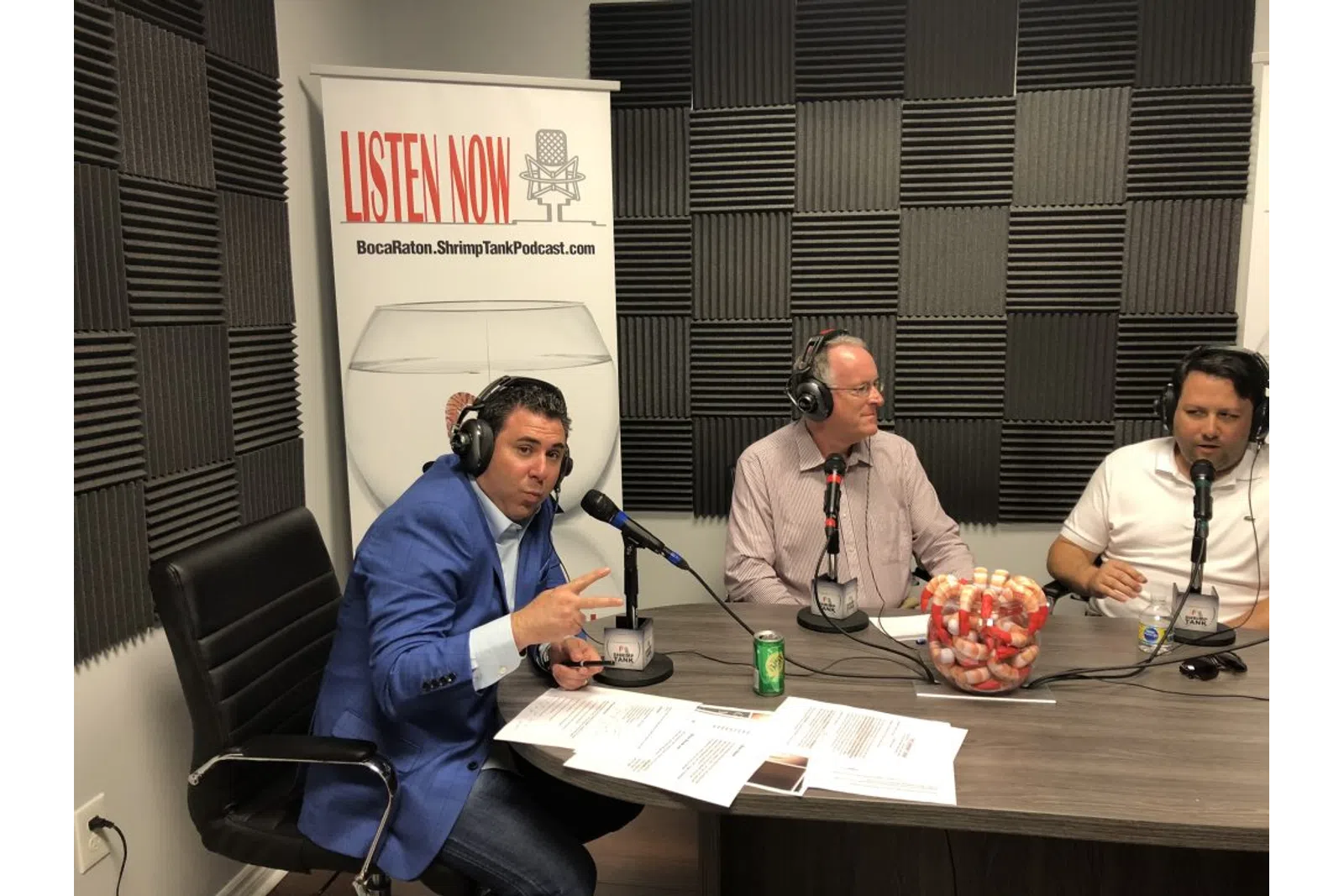 a group of people sitting at a table with microphones