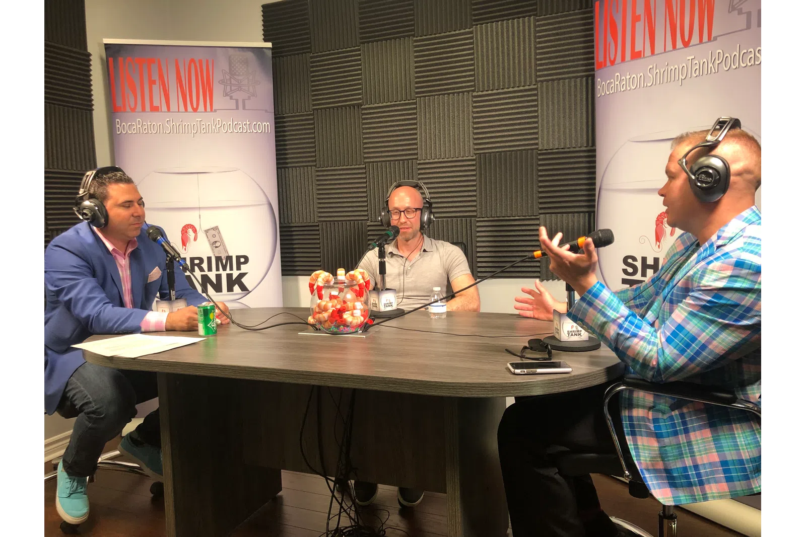 a group of people sitting at a table with headphones on