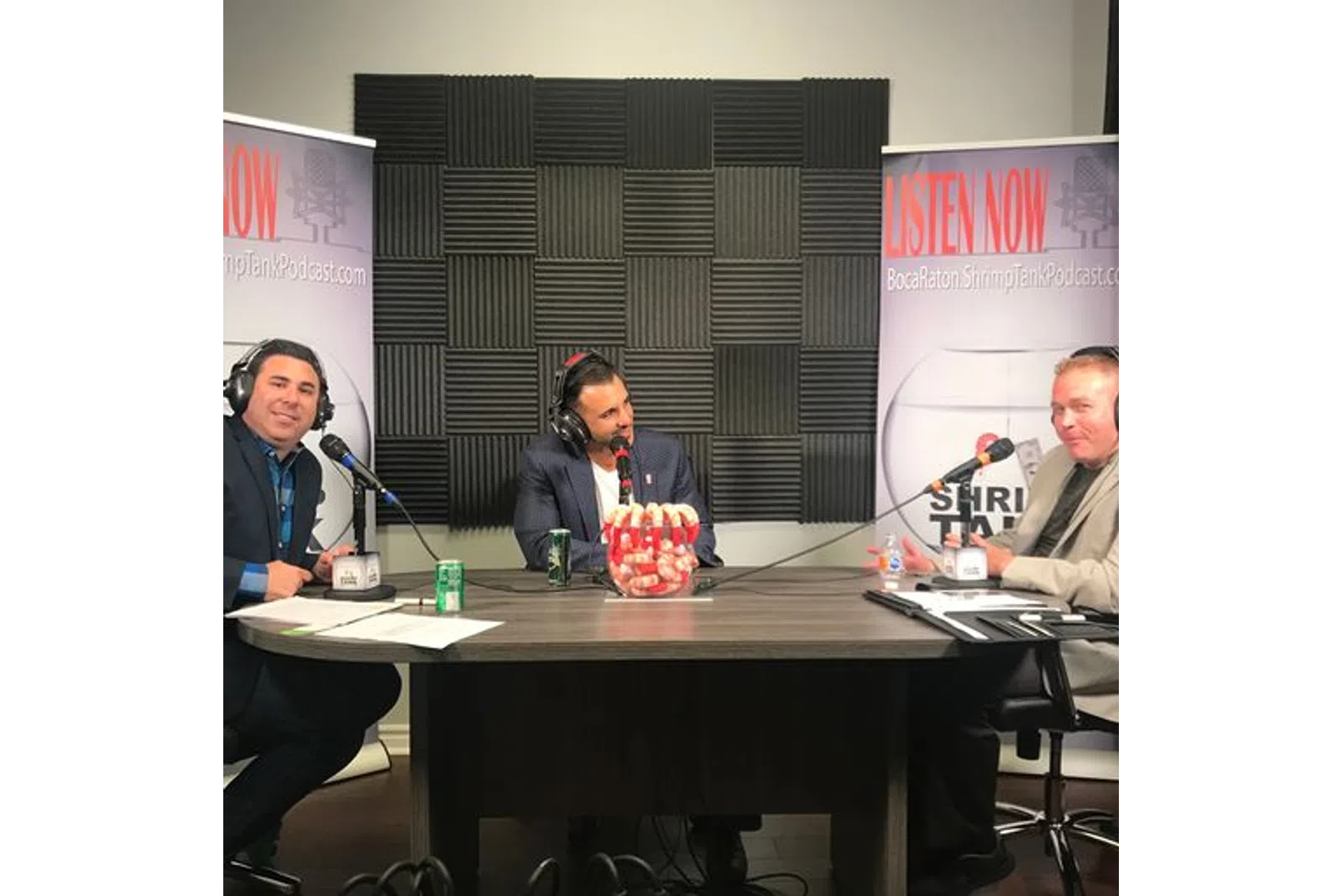a group of people sitting at a table with microphones