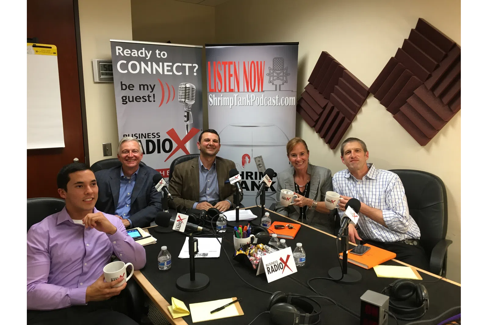 a group of men sitting at a table with microphones