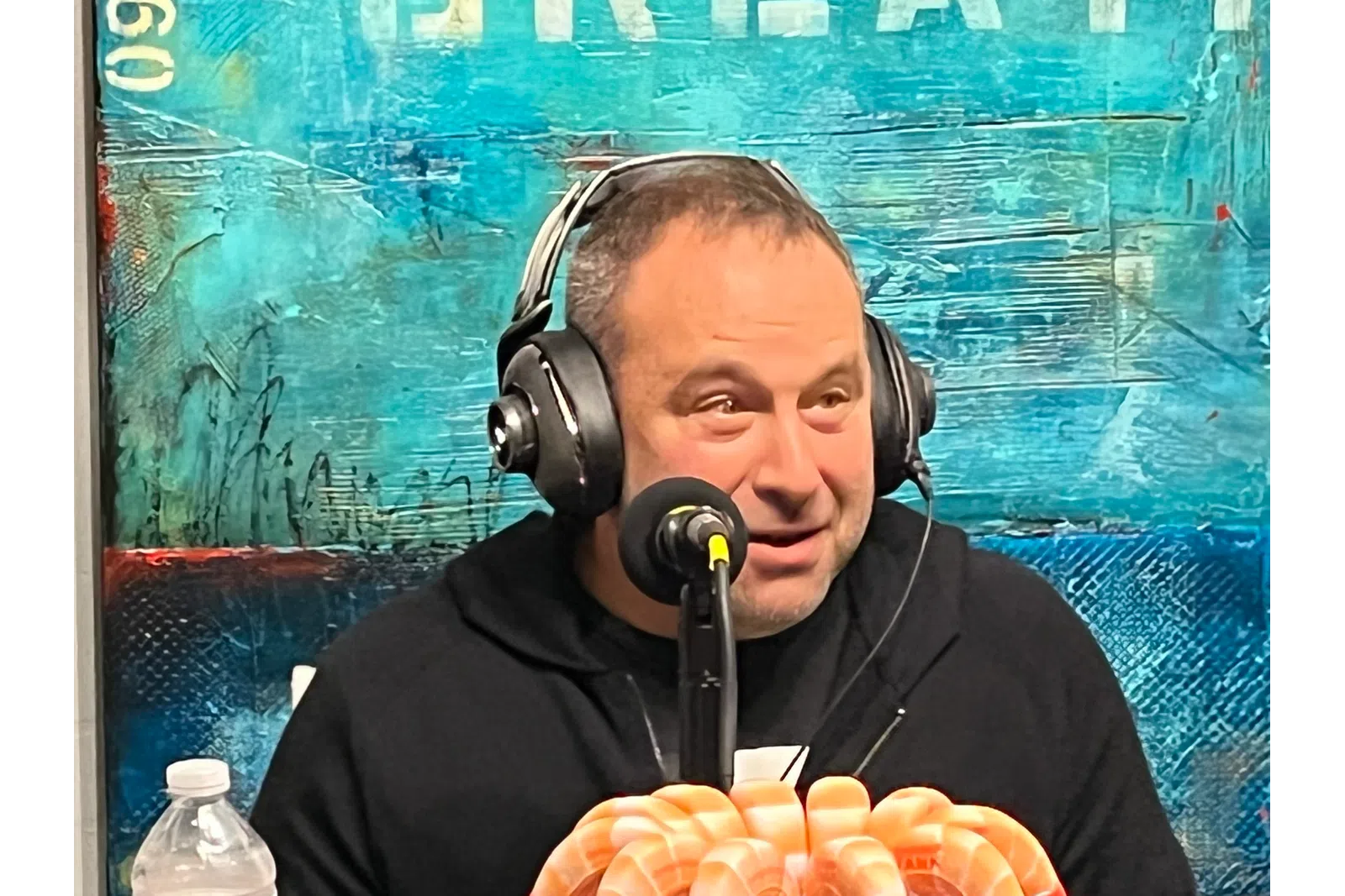 a person wearing headphones and sitting at a table with food