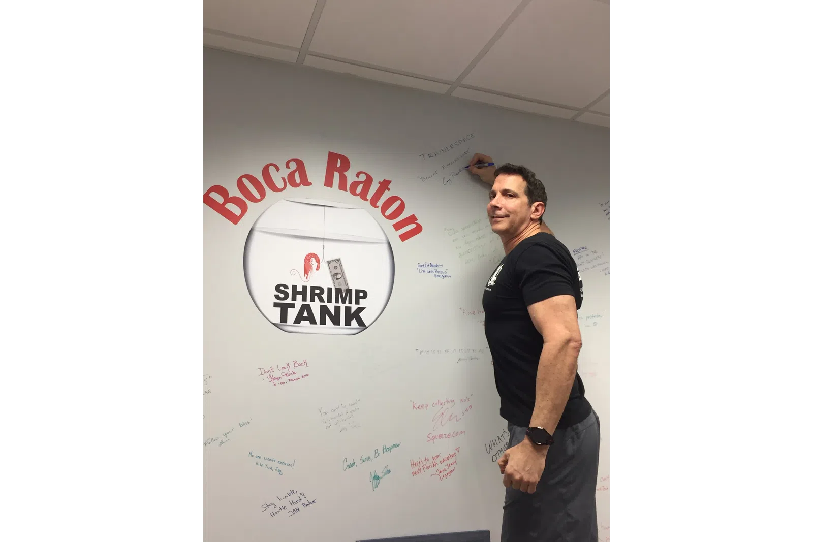 a man standing next to a white board with writing on it