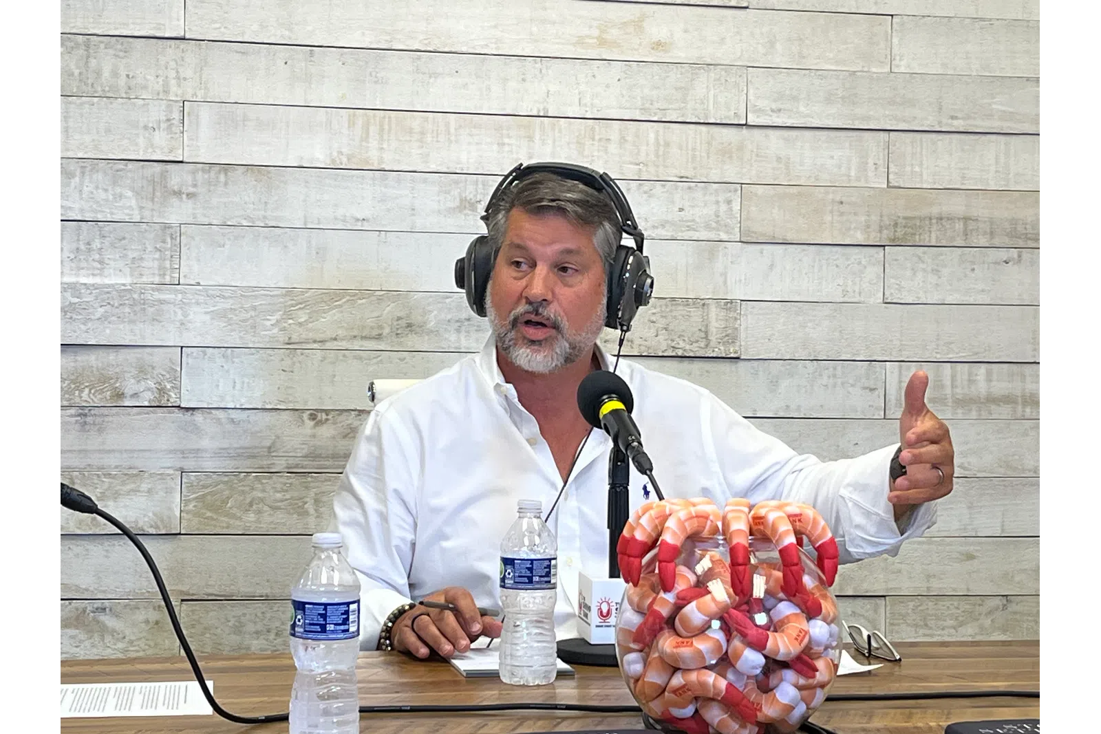 a person wearing headphones and sitting at a table with a basket of fruit