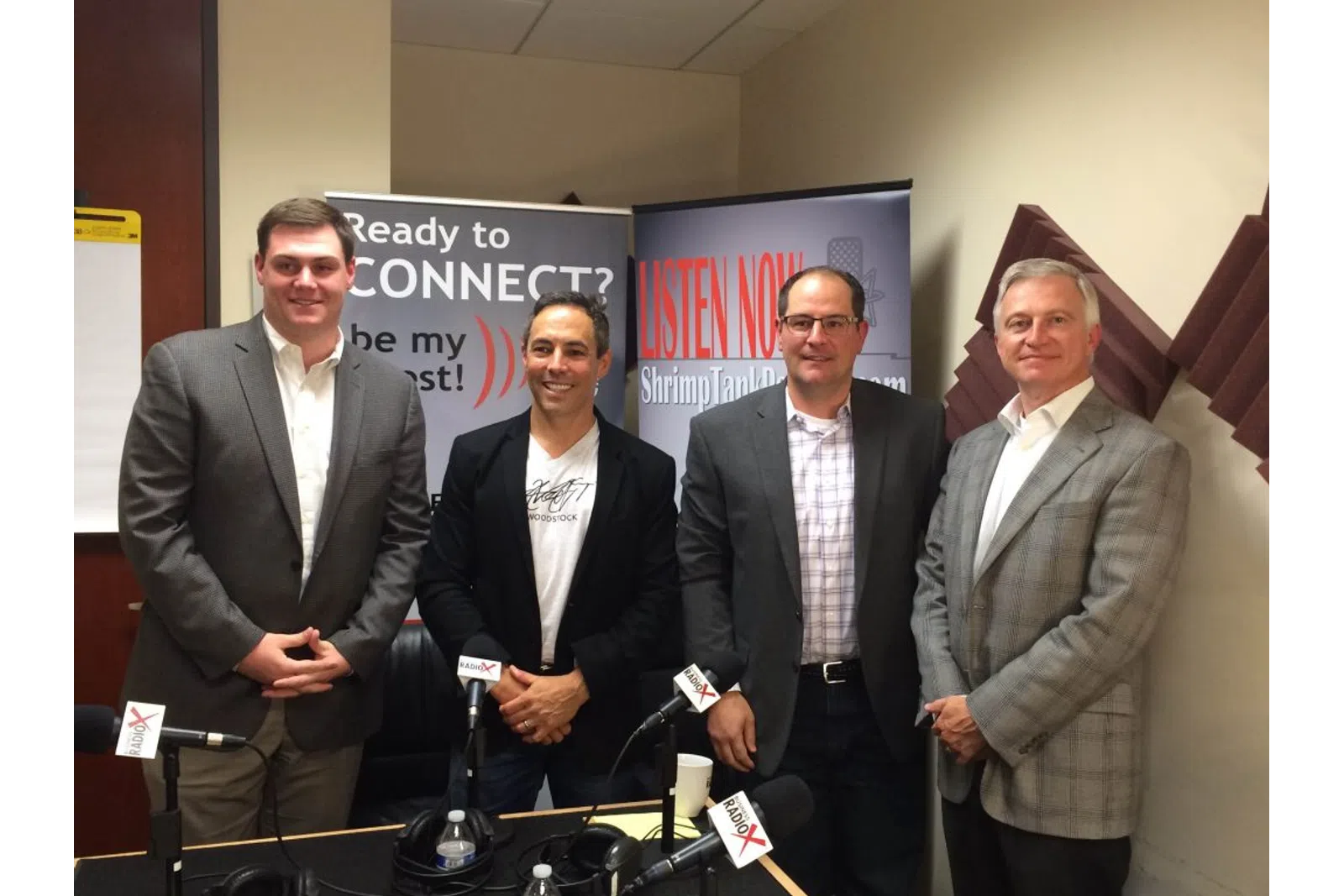 a group of men standing in front of microphones