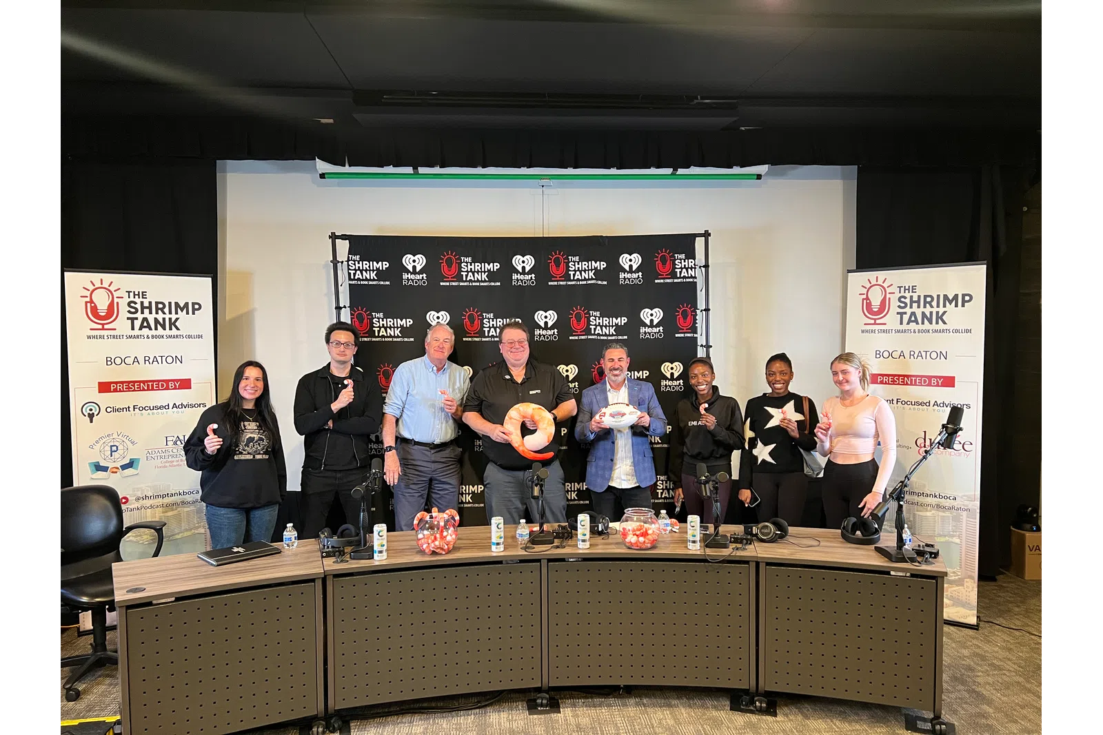 a group of people standing in front of a table with a sign