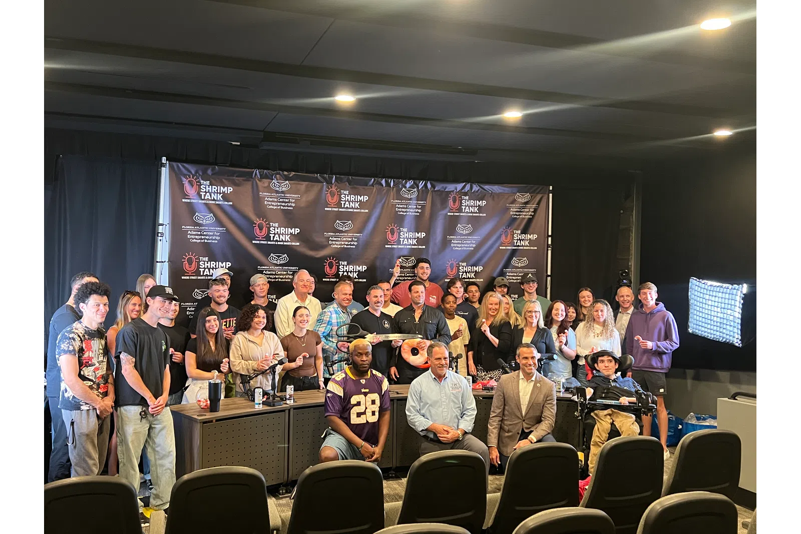 a group of people posing for a photo in front of a screen