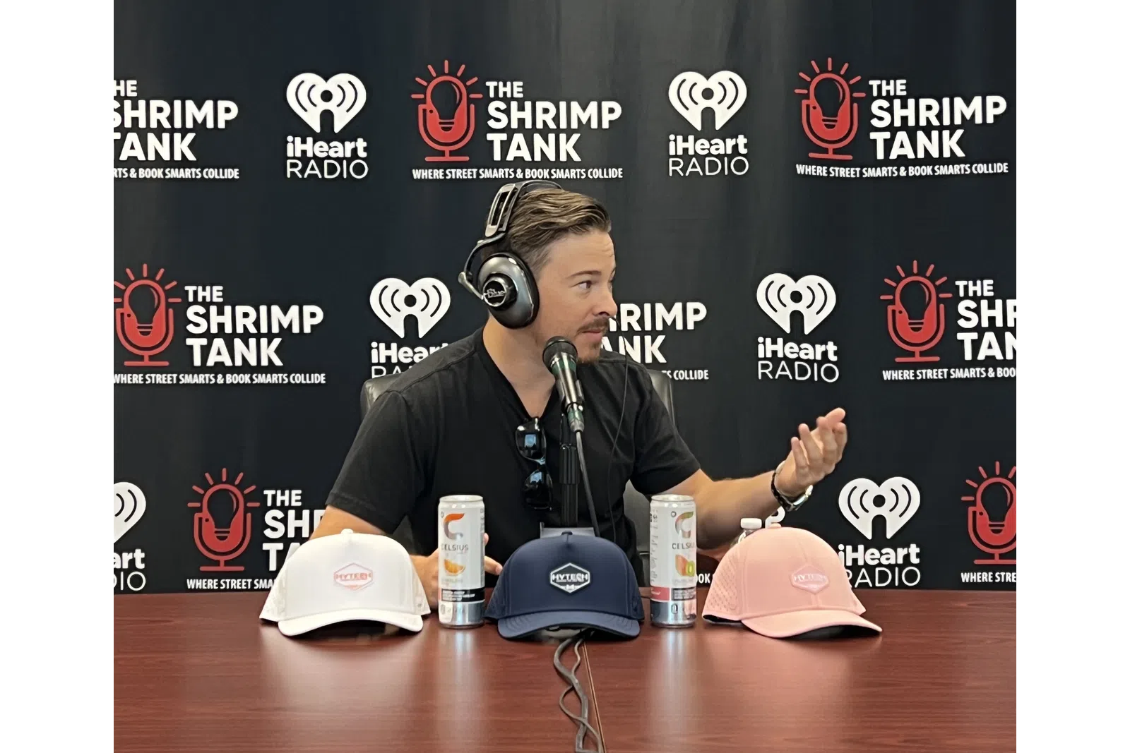 a person wearing headphones and sitting at a table with a microphone