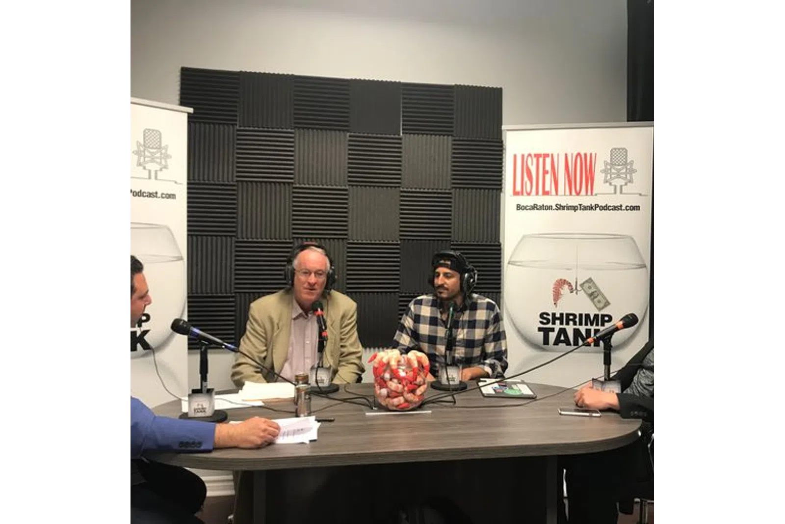 a group of people sitting at a table with microphones