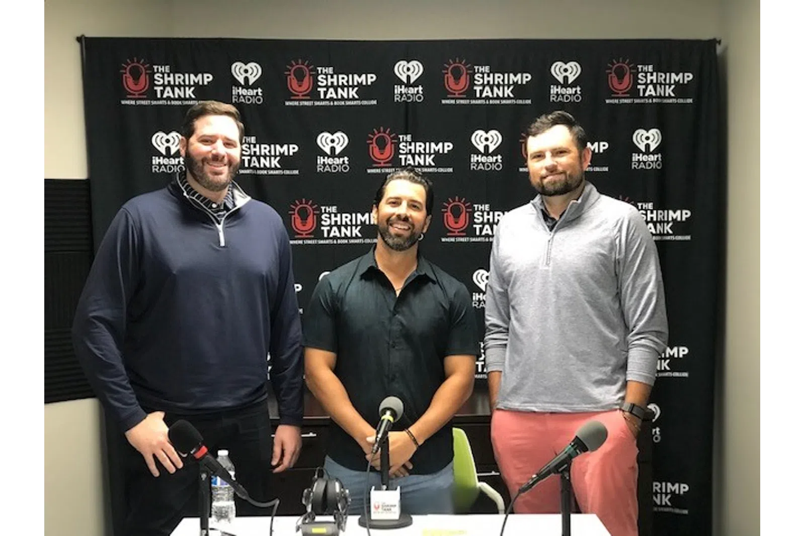 a group of men standing next to microphones