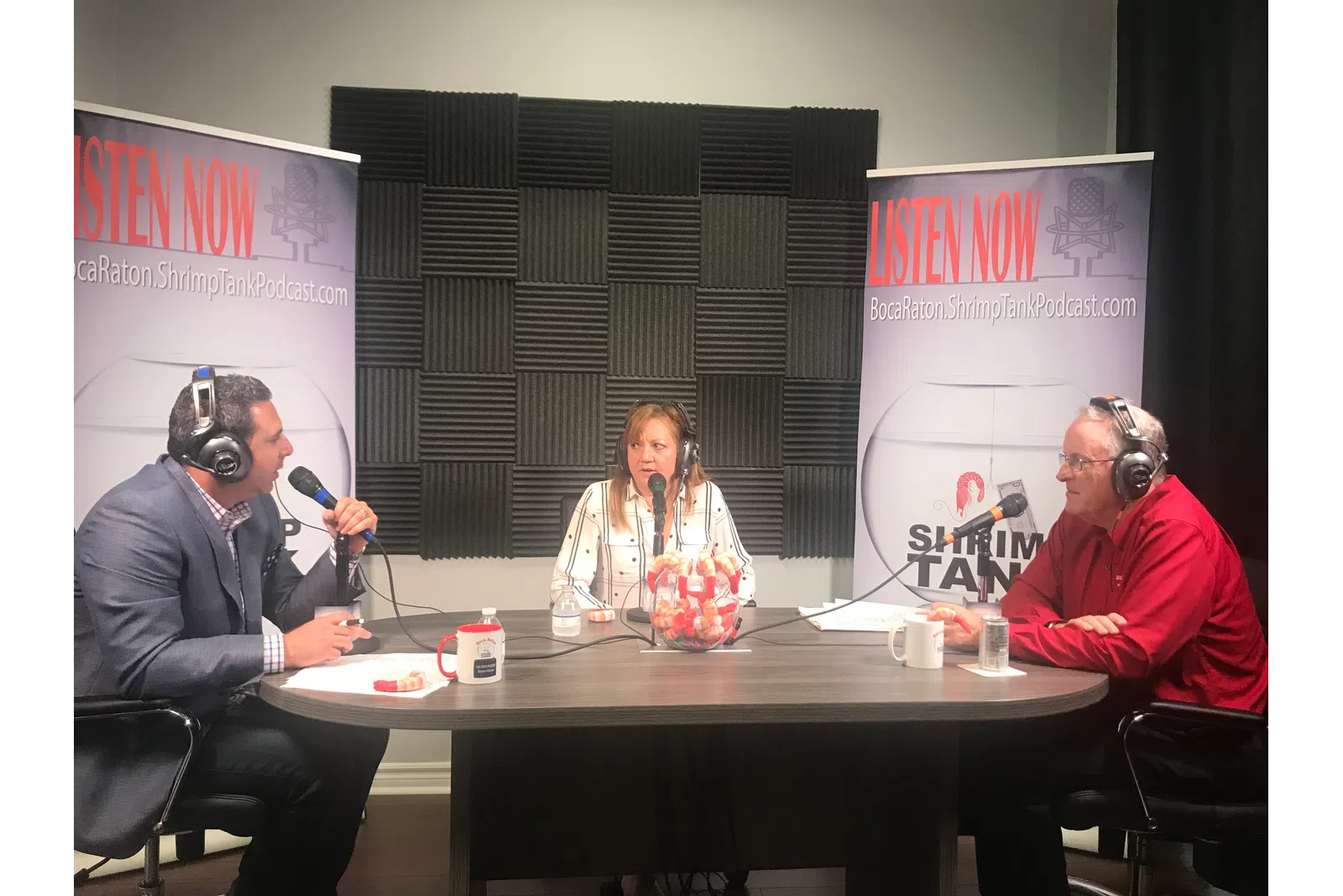 a group of people sitting at a table with microphones