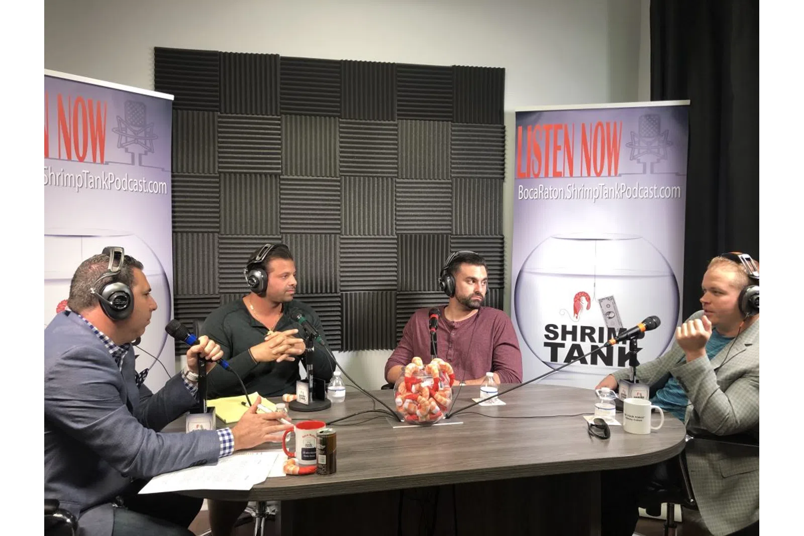 a group of people sitting at a table with microphones