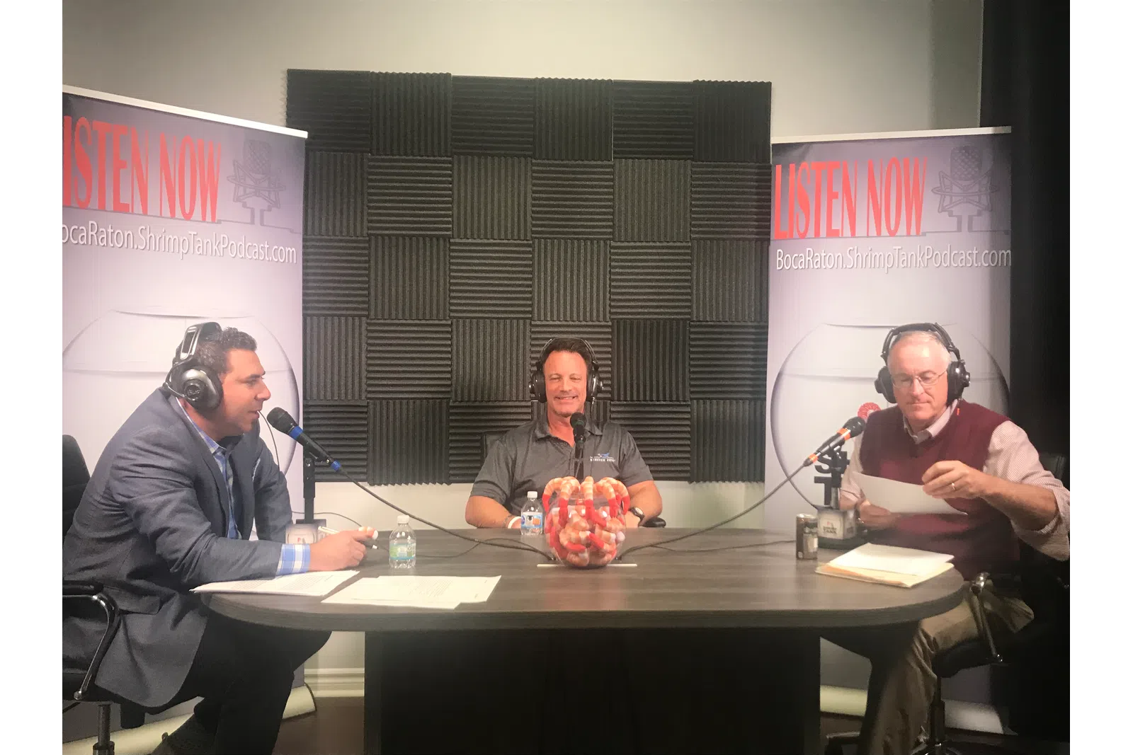 a group of people sitting at a table with microphones