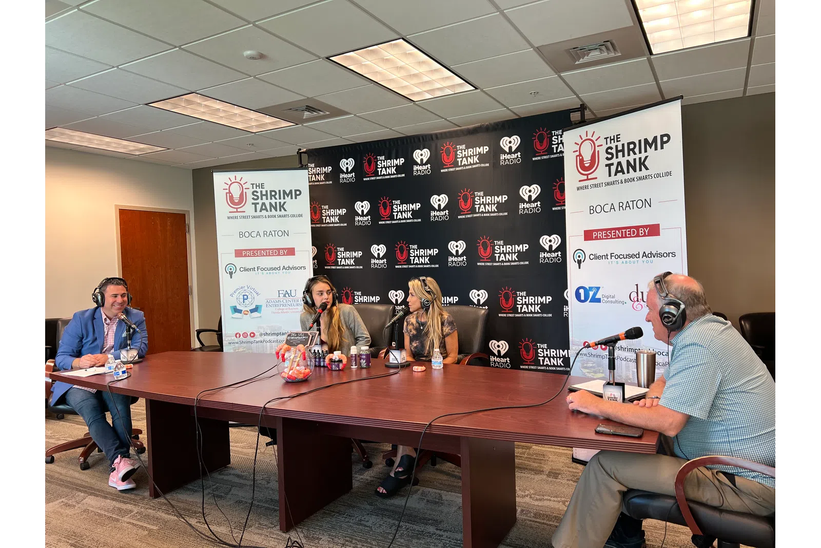 a group of people sitting at a table with microphones