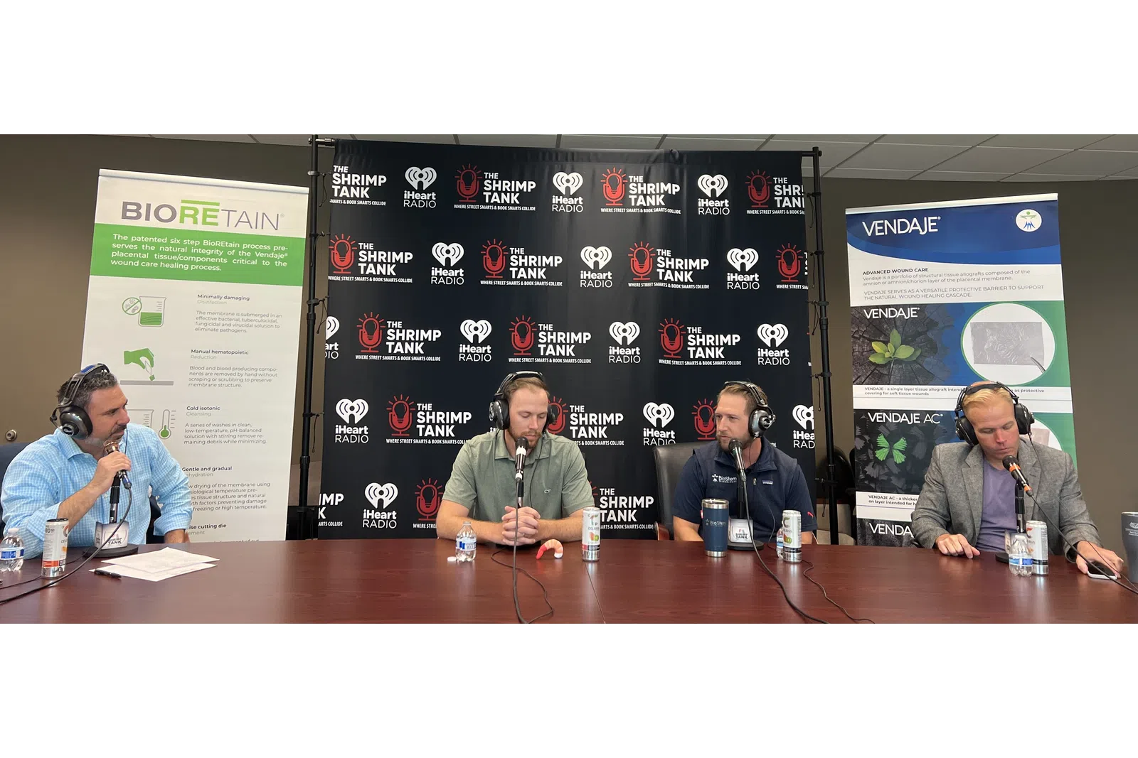 a group of people sitting at a table with microphones