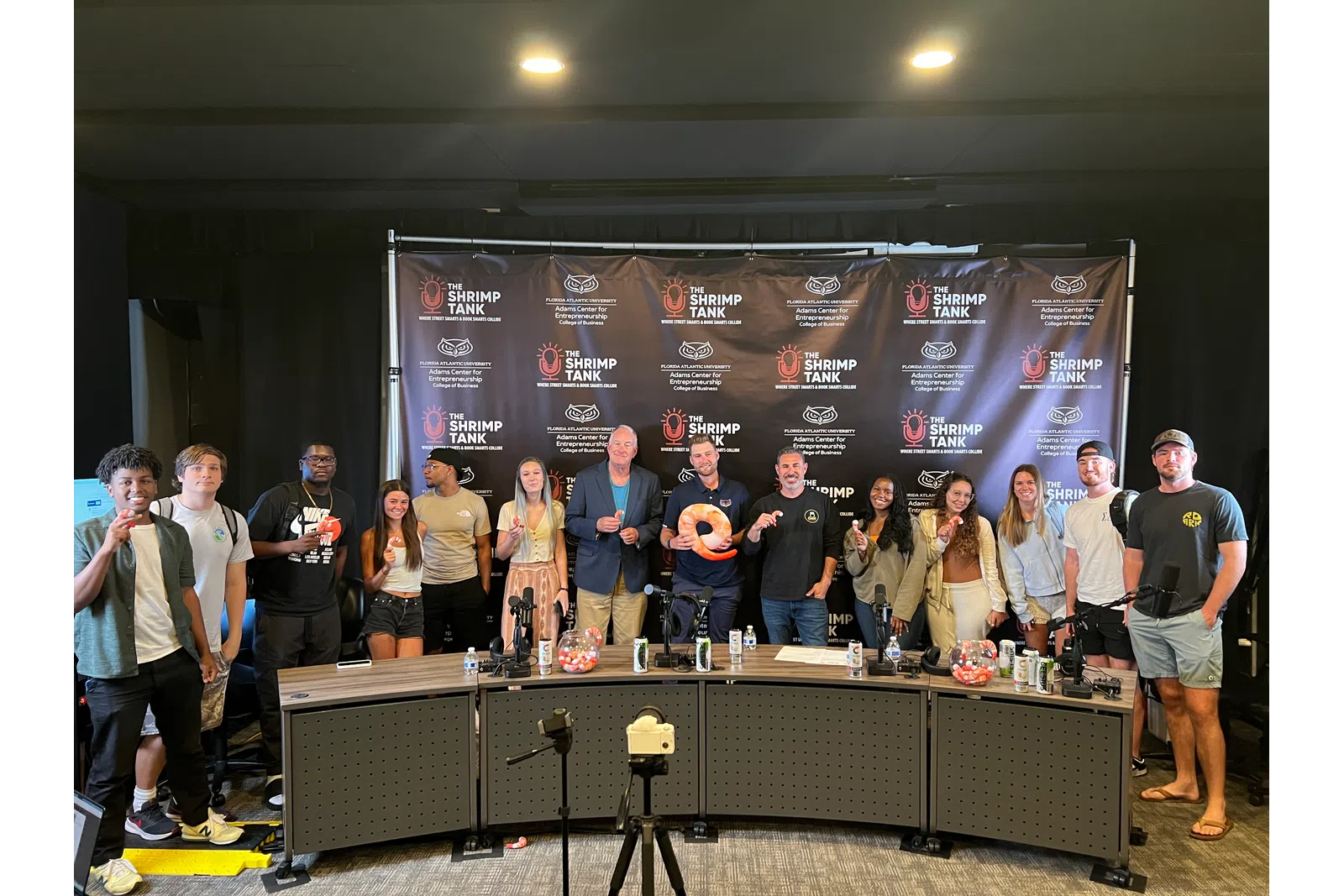 a group of people posing for a photo in front of a large screen