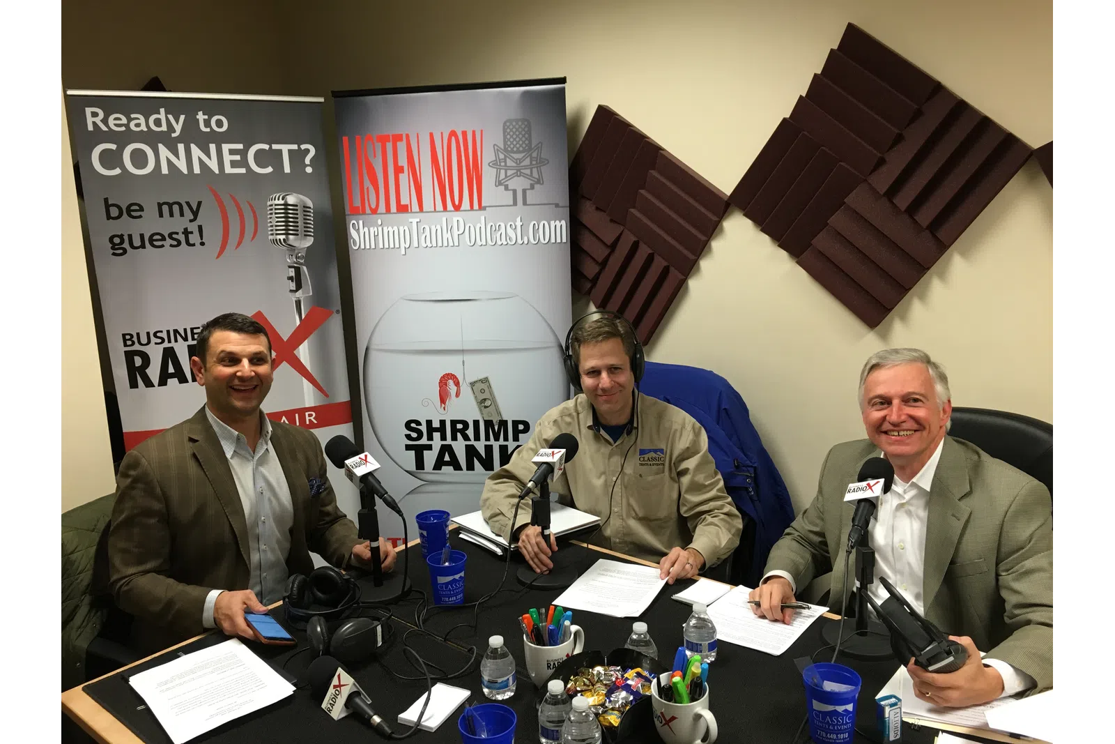 a group of men sitting at a table with microphones
