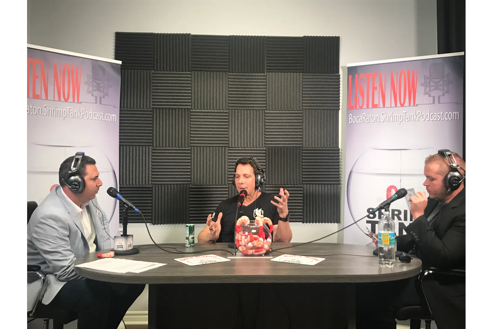 a group of people sitting at a table with microphones