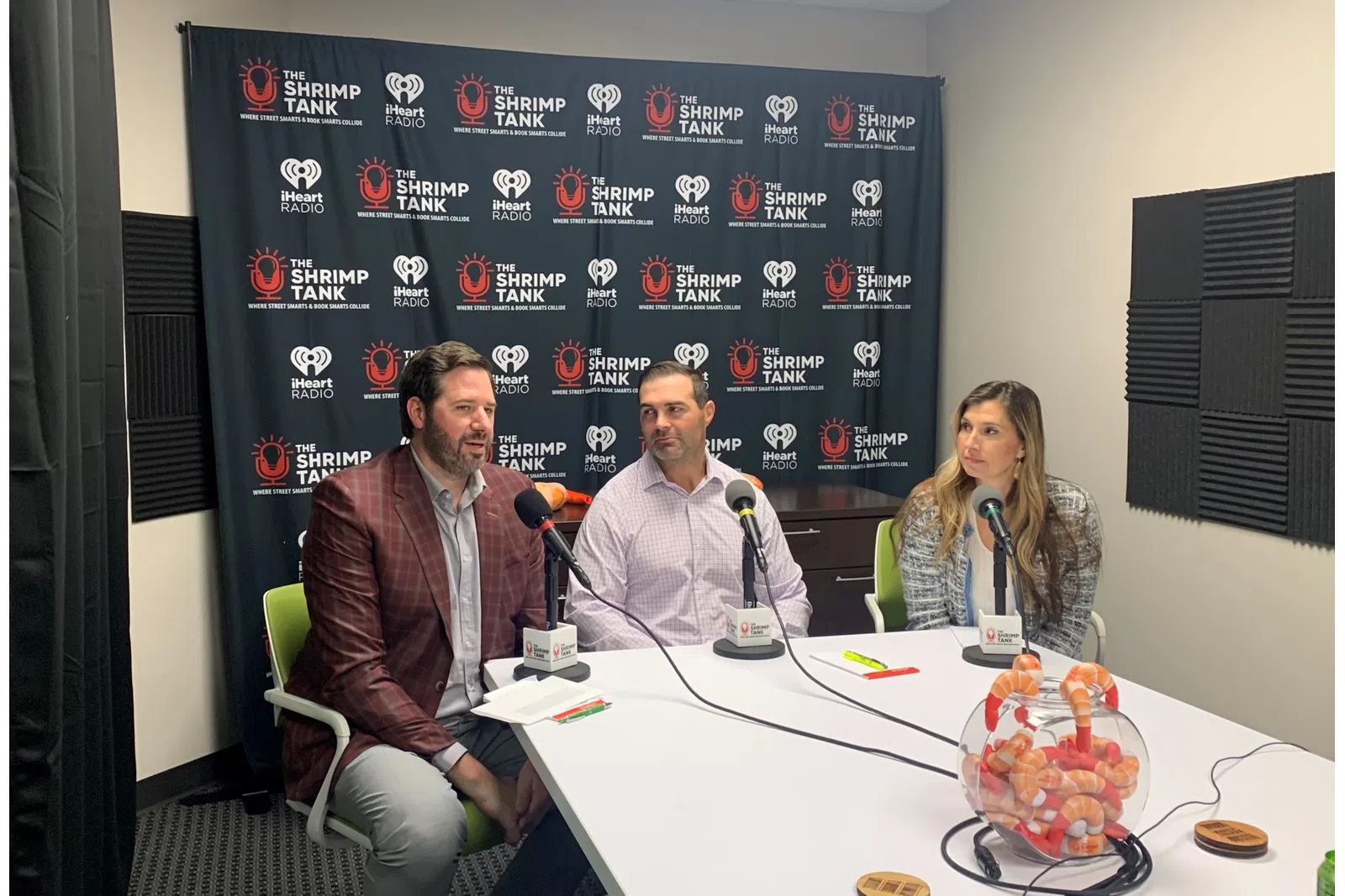 a group of people sitting at a table with microphones