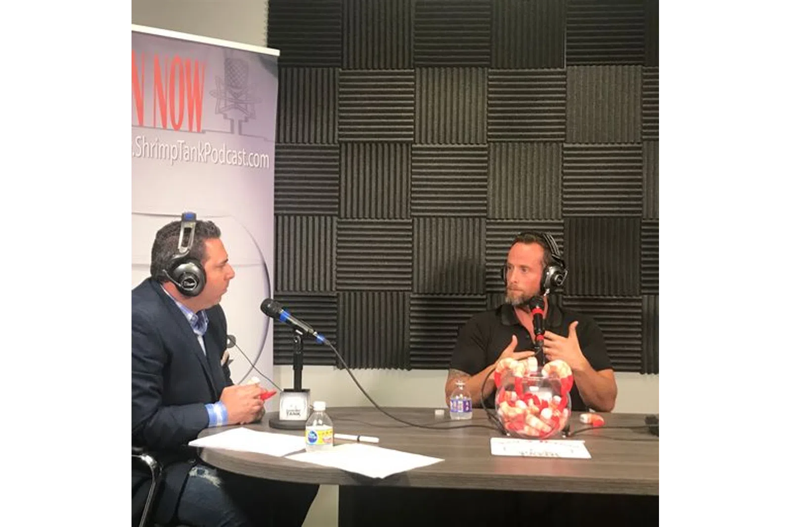 a man wearing headphones and sitting at a table with a microphone