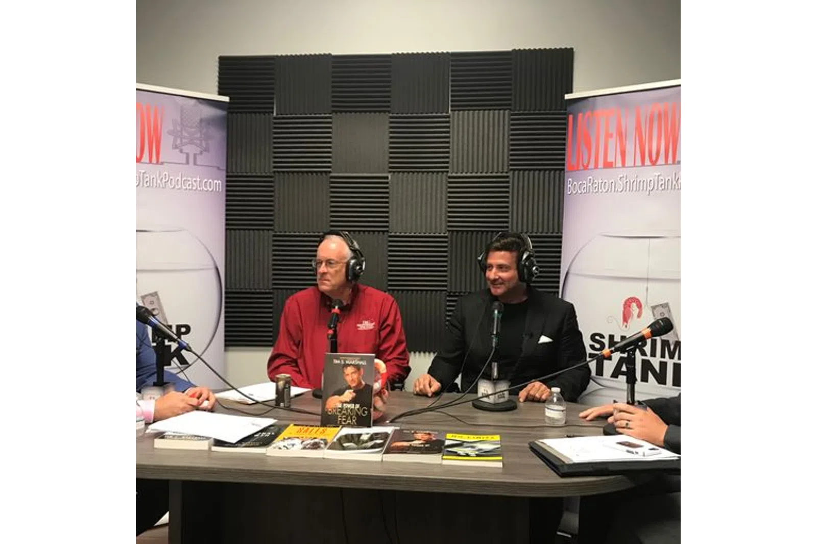 a group of men sitting at a table with microphones