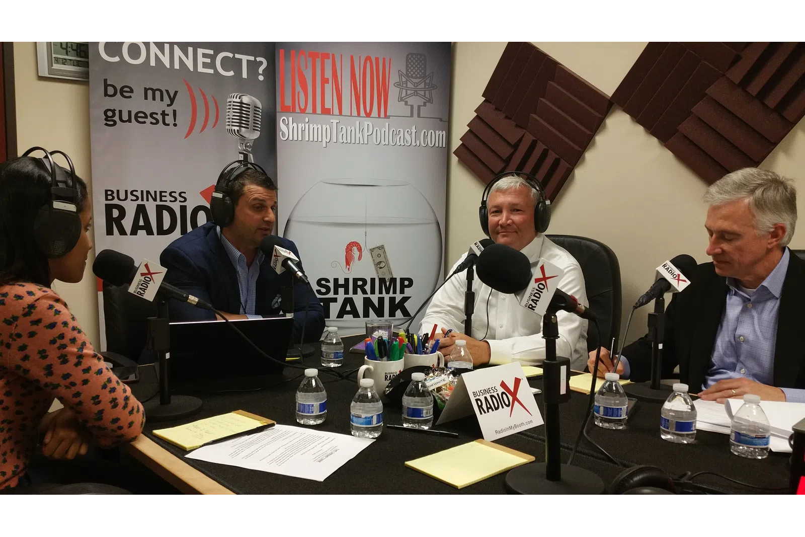 a group of people sitting at a table with microphones