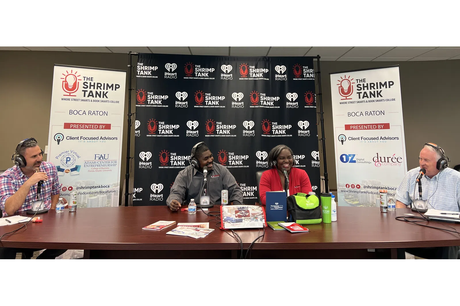 a group of people sitting at a table with microphones