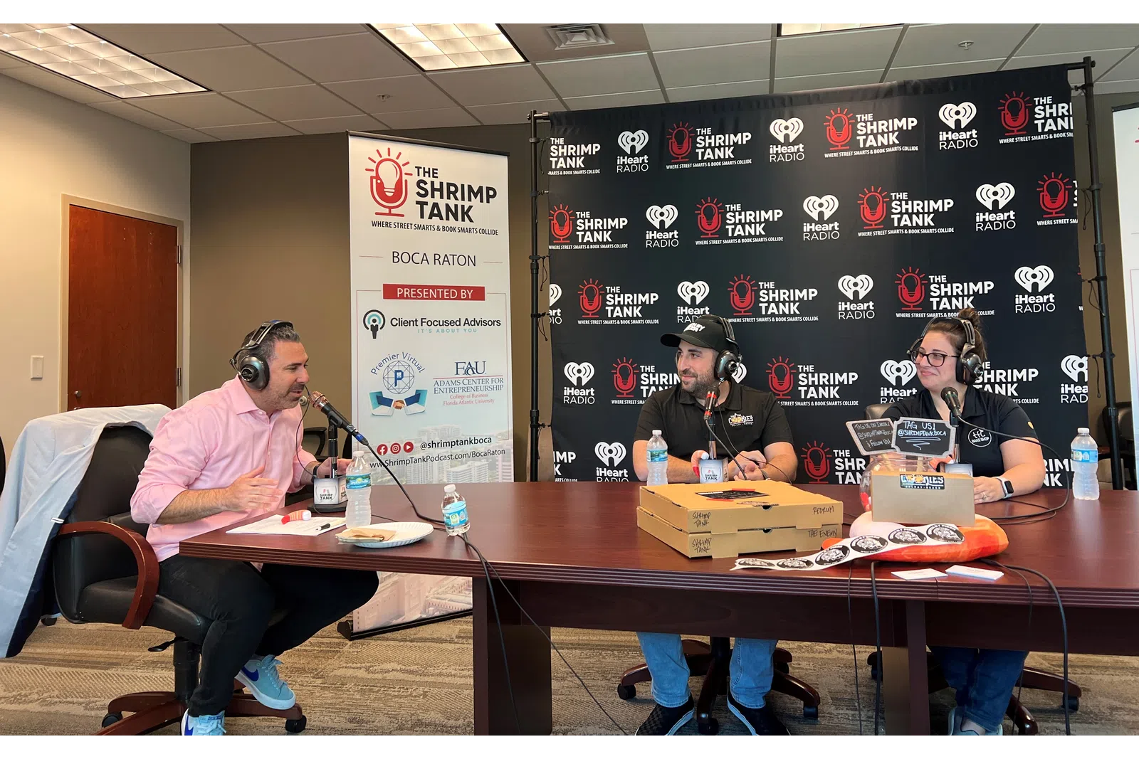 a group of people sitting at a table with microphones