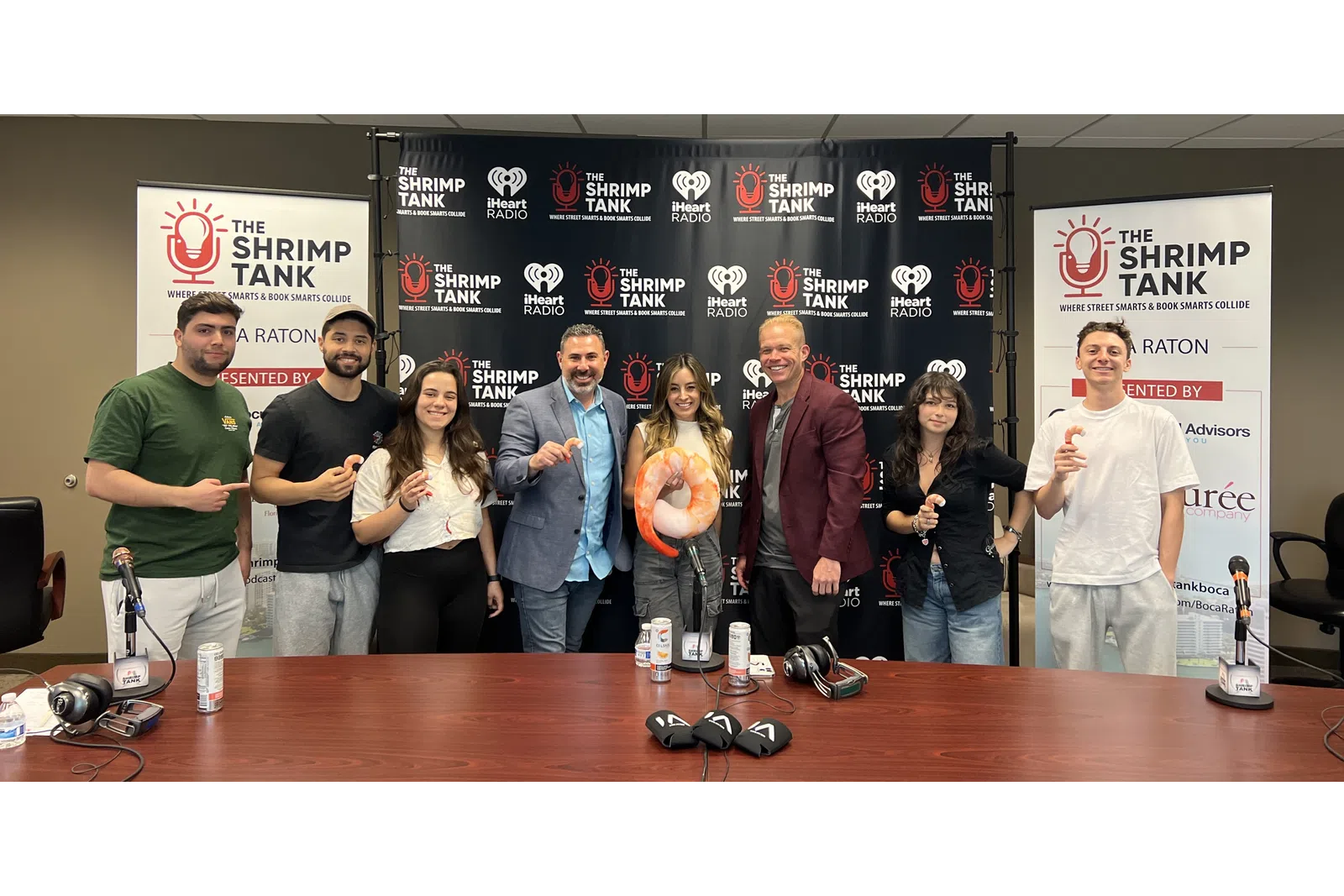 a group of people standing in front of a table with a sign