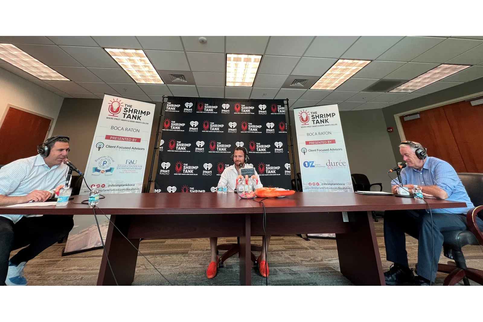 a group of people sitting at a table with microphones