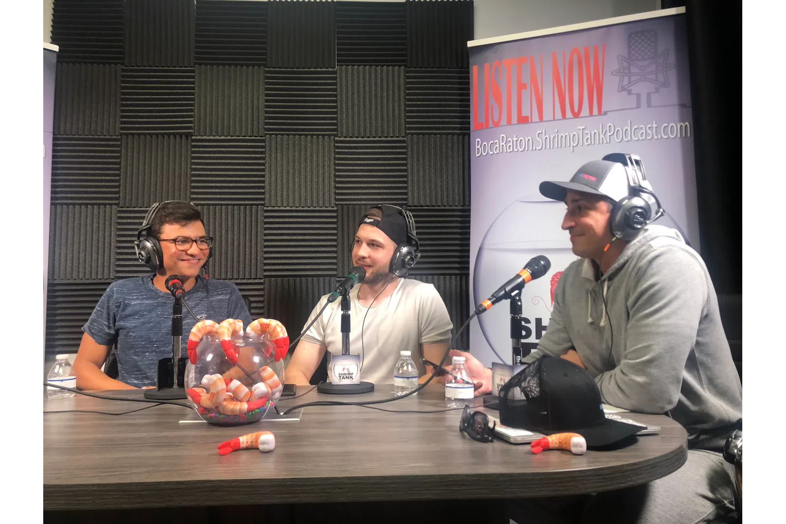a group of people sitting at a table with microphones