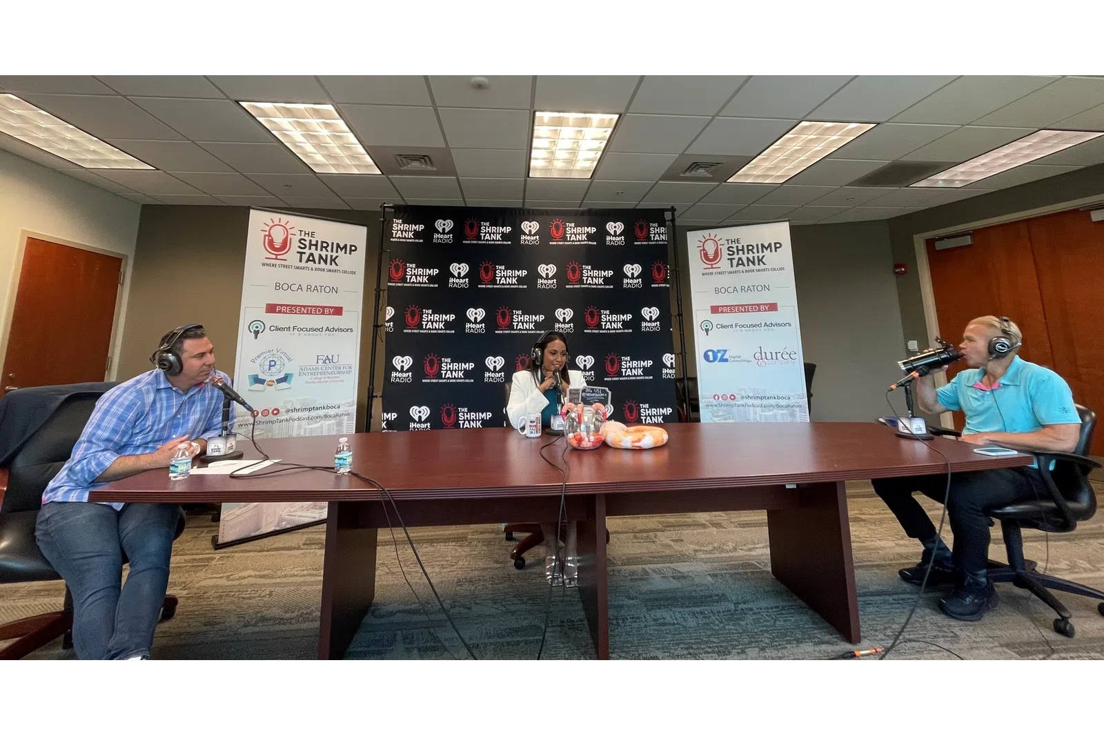 a group of people sitting at a table with microphones