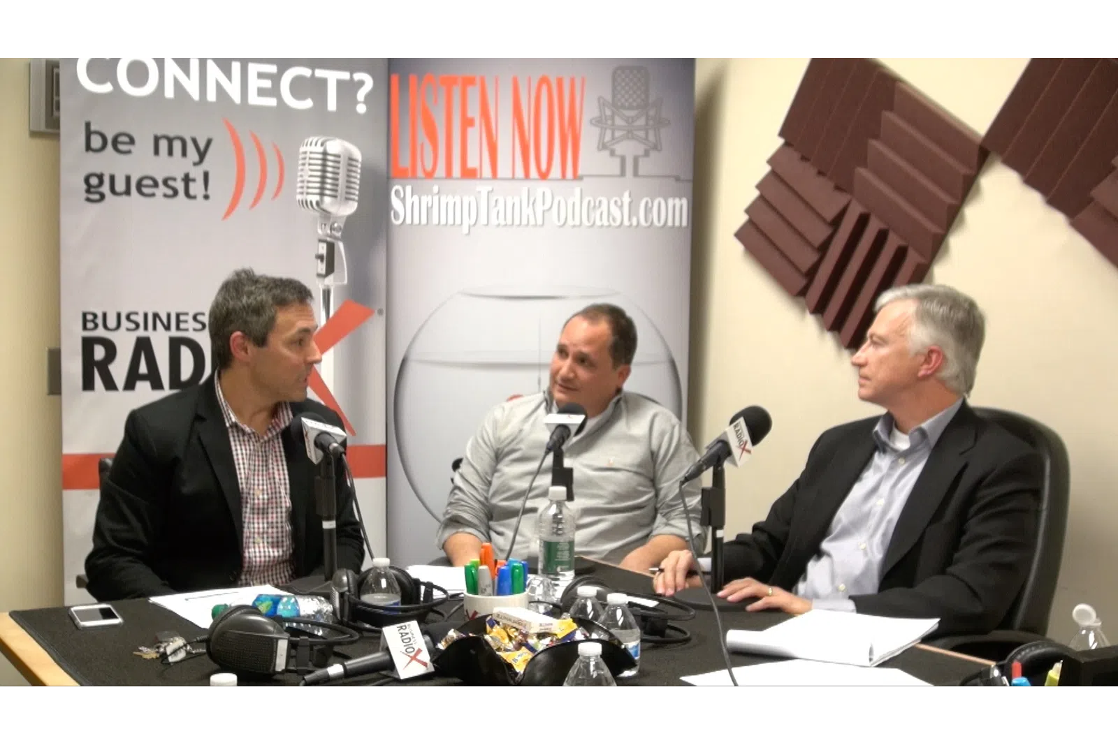 a group of men sitting at a table with microphones